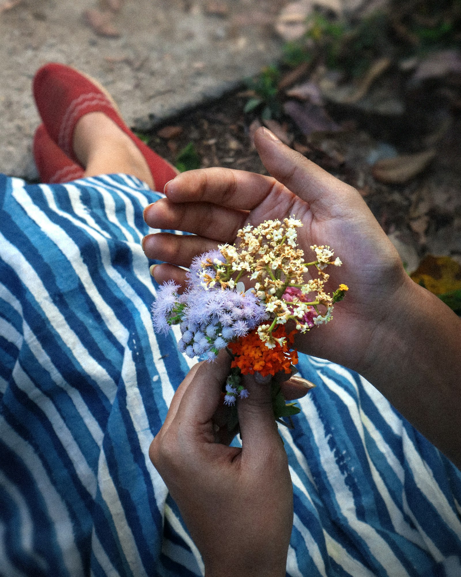 Hands holding a small hand-tied posy of flowers